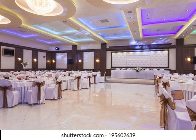Wedding hall or other function facility with colorful ceiling lights set for fine dining 