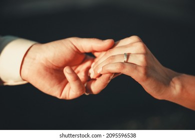 Wedding. Hands of man and woman on dark background on warm soft sunlight. New family is born. High quality photo - Shutterstock ID 2095596538