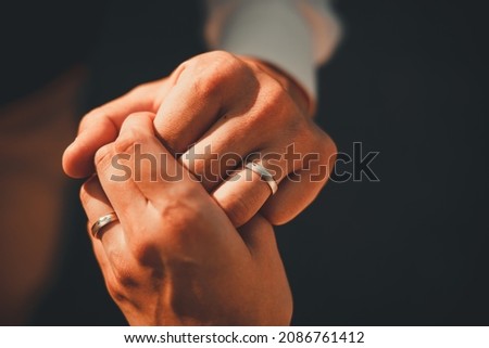 Wedding. Hands of man and woman on dark background on warm soft sunlight. New family is born. High quality photo