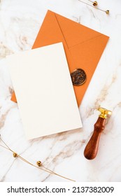 Wedding Invitation Card, Brown Envelope, Wax Seal Stamp On Marble Desk Table With Dry Flowers. Flat Lay, Top View, Copy Space.