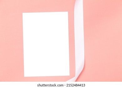 Wedding Invitation Or Greeting Card Mockup. Blank White Card 5x7 With White Satin Ribbon On A Pink Background.