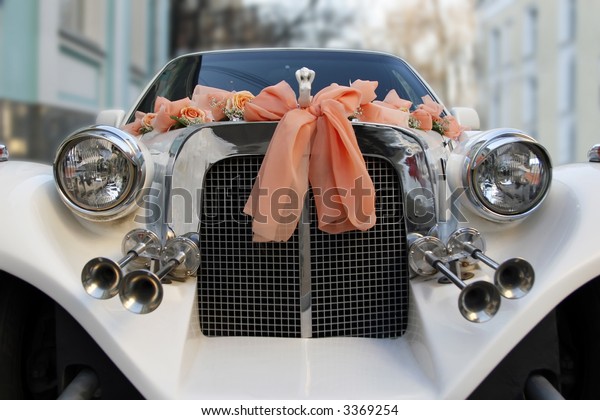 The wedding limousine decorated by\
tapes and colors expects the groom and the bride for\
walk