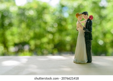 Wedding and love concept : Miniature figurine wedding doll, bride and bridegroom with a bouquet. A wedding is a ceremony where two people united in marriage, exchange of marriage vows by a couple.