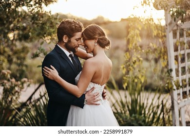 Wedding, love and couple in garden for marriage, ceremony celebration and commitment. Save the date, trust and bride and groom hug, embrace and happy to celebrate romance, smile and loving in park - Powered by Shutterstock