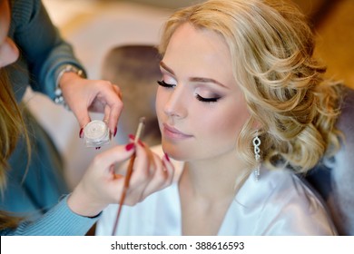 Wedding Makeup Artist Making A Make Up For Bride. Beautiful Sexy Model Girl Indoors. Beauty Woman With Curly Hair. Female Portrait. Bridal Morning Of A Cute Lady. Close-up Hands Near Face