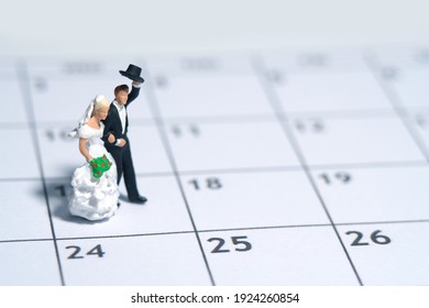 Wedding marriage day, schedule date celebration concept miniature people toy photography. Bride and groom standing above calendar. Image photo