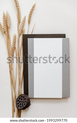 Wedding mock up top view. Flat lay blank invitation card, brown envelope on pastel beige background.