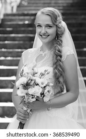 Wedding. No Wedding Day Nerves Today! Monochrome Soft Focus Portrait Of A Young Woman In A Wedding Dress Posing With Flowers In Her Hands 