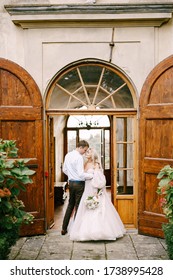 Wedding At An Old Winery Villa In Tuscany, Italy. A Wedding Couple Is Standing Near The Old Wooden Doors In The Villa-winery.