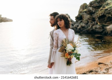 Wedding On The Sunset With Live Floristry. Bride And Groom In Boho Style. 