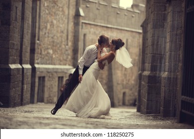 wedding pair hugging and kissing at the gate - Powered by Shutterstock