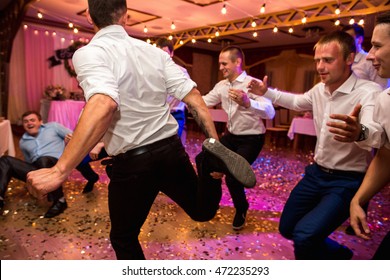 Wedding party. Groomsmen having fun and dancing at wedding banquet. Selective focus