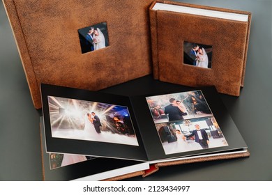 Wedding Photobooks In Brown Leather Binding With Photos On The Cover. High-quality And Expensive Photo And Printing Products. Services Of A Professional Photographer And Designer. On Black Background