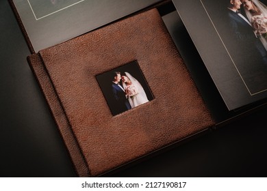 Wedding Photobooks In Brown Leather Binding With Photos Of The Newlyweds On The Cover. High-quality And Expensive Photo And Printing Products. Services Of A Professional Photographer And Designer.