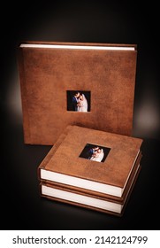 Wedding Photobooks In Brown Leather Binding With Photos Of The Newlyweds On The Cover. High-quality And Expensive Photo And Printing Products. Services Of A Professional Photographer And Designer.