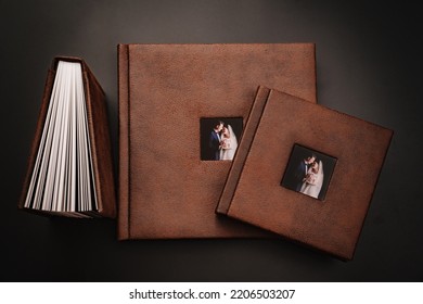 Wedding Photobooks In Brown Leather Binding With Photos Of The Newlyweds On The Cover. High-quality And Expensive Photo And Printing Products. Services Of A Professional Photographer And Designer.