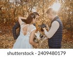 wedding photographer shows just taken photos to wedding couple. bride and groom in nature