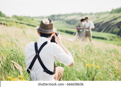 wedding photographer takes pictures of bride and groom in nature in summer, fine art photo