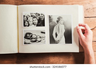 Wedding photos in album. Studio shot on wooden background. - Shutterstock ID 324186077