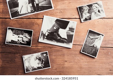 Wedding photos laid on a table. Studio shot on wooden background. - Shutterstock ID 324185951