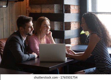 Wedding planner meet with couple in cafe discuss moments of upcoming event. Photographer show professionals quality of pictures to potential clients. Diverse colleagues talk during lunch break concept - Powered by Shutterstock