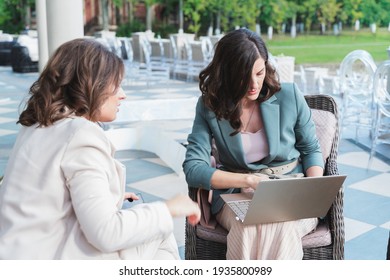Wedding planners, organizers, event decorators, managers with laptop.Business meeting,negotiations,project discussion,signing contract with client,customer.Women, girls in stylish suits in restaurant.