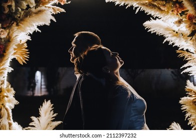 Wedding Portrait, Photography, Silhouette Of A Stylish Groom On The Background Of An Arch Of Reeds At Night. Wedding Photography, Portrait.