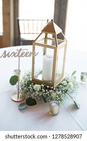 Wedding Reception Centerpiece With Gold Lantern With Table Number And Floral Arrangement