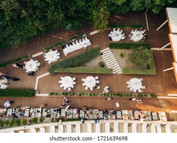 Wedding Reception Table Setting, Dinner By The Sea Aerial Top View. Guests At The Wedding Banquet Sit At The Table, The Photo Was Taken By A Drone. 