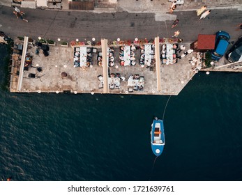 Wedding Reception Table Setting, Dinner By The Sea Aerial Top View. Guests At The Wedding Banquet Sit At The Table, The Photo Was Taken By A Drone. 