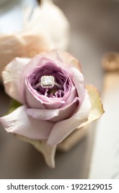 A wedding ring in a purple rose close up