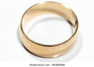 A wedding ring is a white table close up.