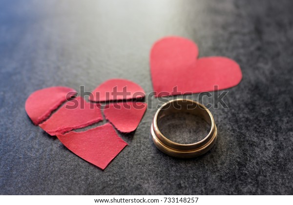 結婚戒指和破碎的紅心 黑色背景 離婚 離別 不忠的概念 選擇性焦點 庫存照片 立刻編輯