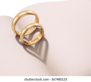 Wedding rings casting heart shaped shadow over a blank book - Shutterstock ID 367480133