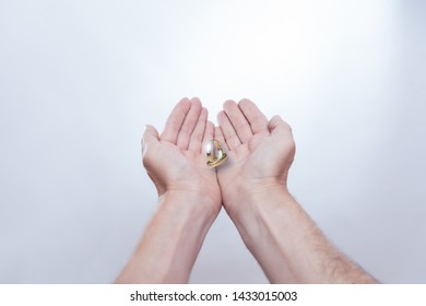 Wedding Rings Floating In The Hands Of A Couple