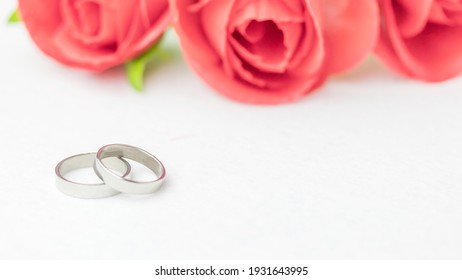 Wedding rings lie near a beautiful bouquet as bridal accessories.Wedding rings and roses bouquet.concept for a wedding card.