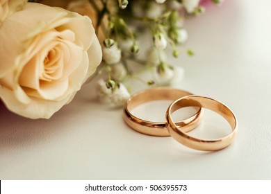 wedding rings lie on a beautiful bouquet as bridal accessories