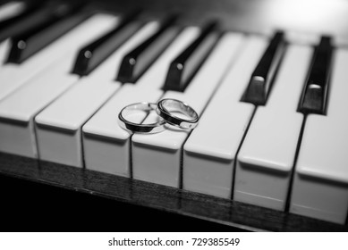 wedding rings lie on the keys of a piano