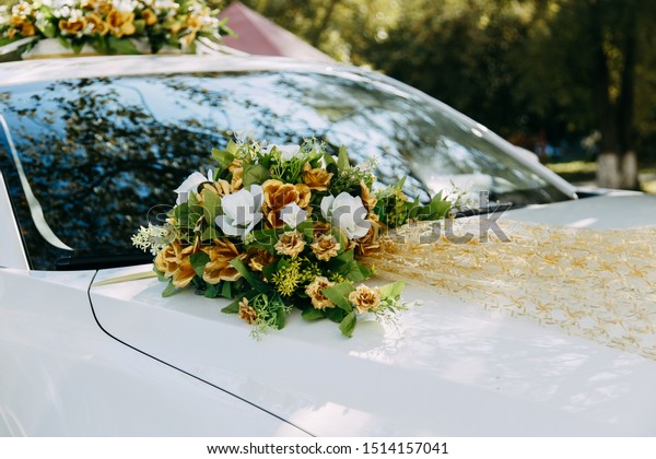 Wedding. Wedding rings on a wedding car. The hood of\
the car.