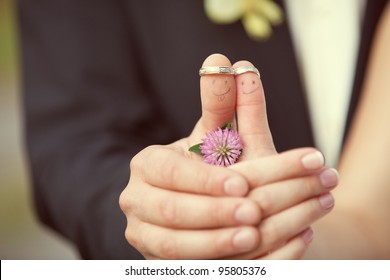 wedding rings on her fingers painted with the bride and groom, funny little men