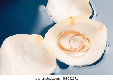 Wedding Rings On The Rose Petals Floating In Water Macro