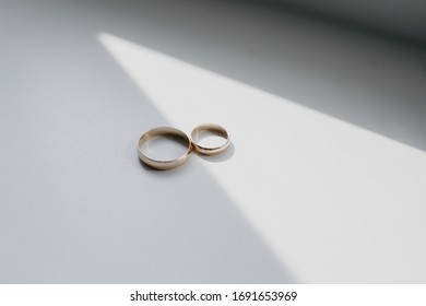 Wedding rings on the white background with shadows - Shutterstock ID 1691653969