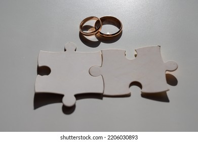Wedding rings and puzzle pieces. Husband and wife complement each other perfectly. - Shutterstock ID 2206030893