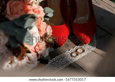 Wedding rings, red shoes and bouquet
