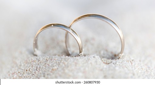 Wedding Rings In Sand On Tropical Beach
