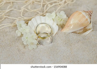 Wedding Rings In Sand With Seashells