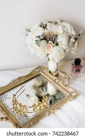 Wedding rustic bouquet, decorative mirrored tray and bridal crown on nightstand. Bridal room interior. 