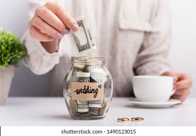 Wedding savings. Woman throwing dollars in jar with money for wedding - Powered by Shutterstock