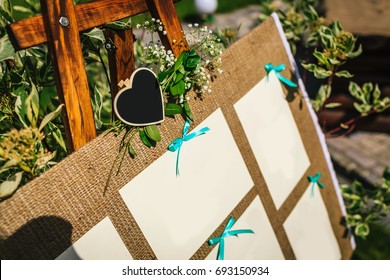 Wedding seating chart on the easel in the park. Close-up image. Outdoors. Copy space