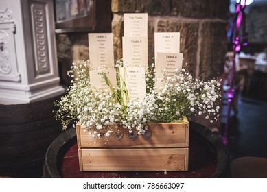 wedding seating plan displayed on cards with a bunch of white flowers